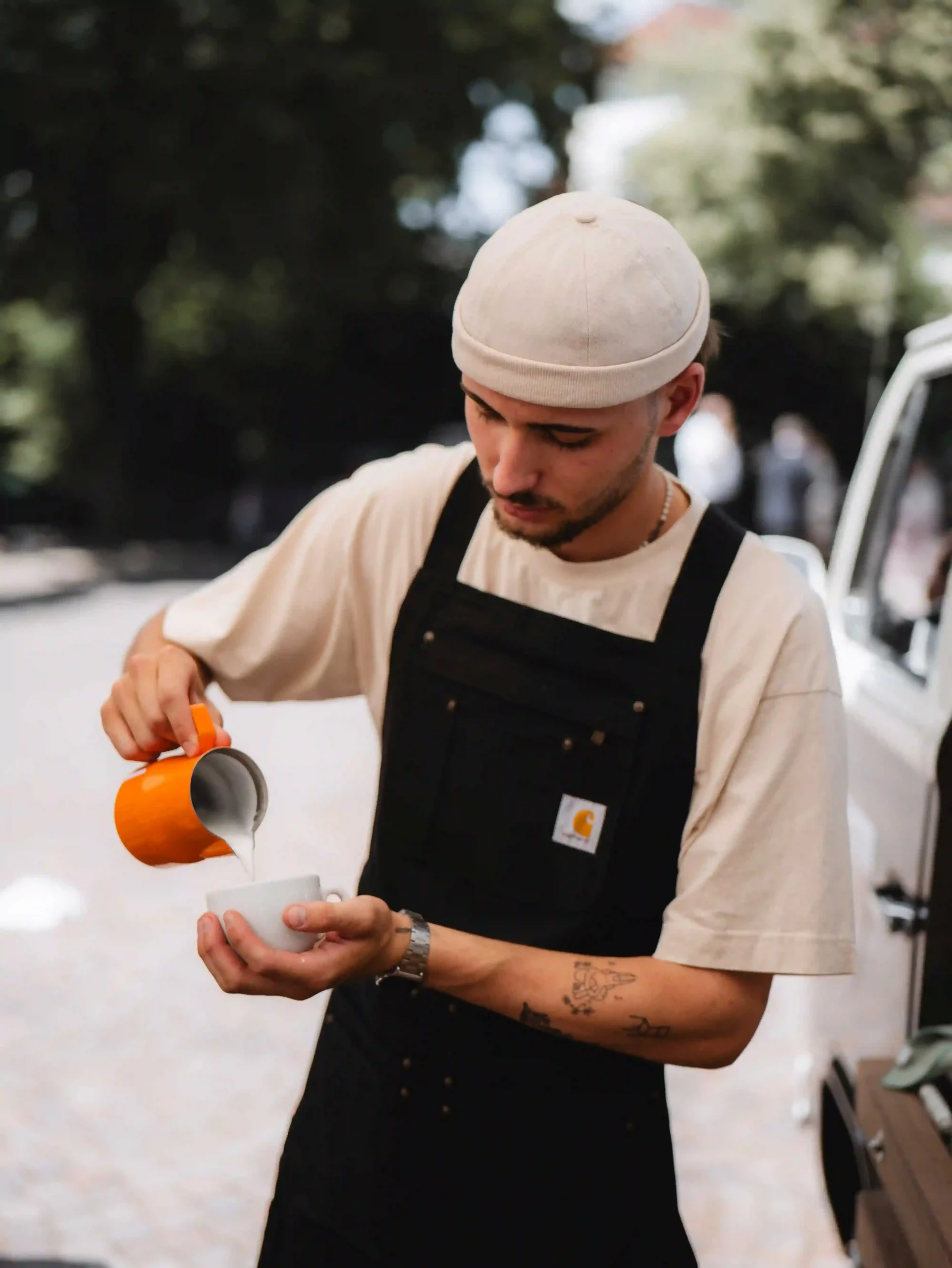 Barista macht Latte Art mit einem Cappuccino