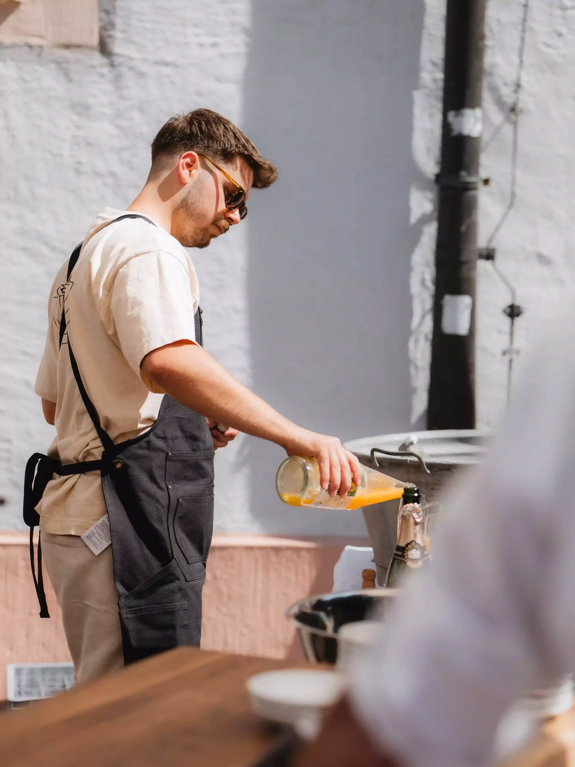 Servicepersonal schenkt Sekt mit O-Saft ein